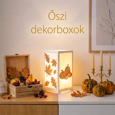 Őszi dekorációs dobozok, tökök, gyertyatartók és falevelek egy világító, meleg színű enteriőrben.